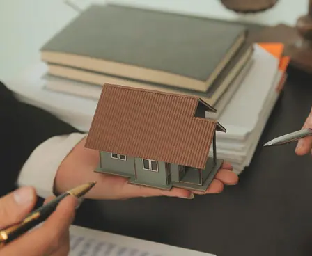 Advogado analisando maquete de imóvel e documentação de registro